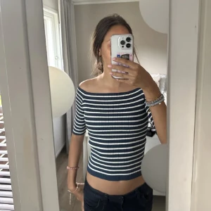 Randig offshoulder topp med 3 kvarts armar  - Randig offshoulder topp i svart och vit. Toppen är ribbad och har en tight passform, aldrig använt. 