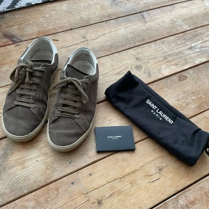 Saint Laurent skor - Tjena! Säljer ett par bruna sneakers från Saint Laurent med tillbehör i storlek 41-42. Skorna har använts en del men har kvar att ge! Säljer för 1999 men pris kan diskuteras! Vid frågor är det bara att höra av er:)