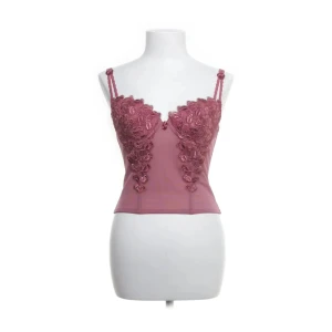 Rosa korsett med spetsdetaljer - Snygg rosa korsett med spetsdetaljer och justerbara axelband. Den är i nyskick, pris går alltid att diskutera vid SNABB affär!