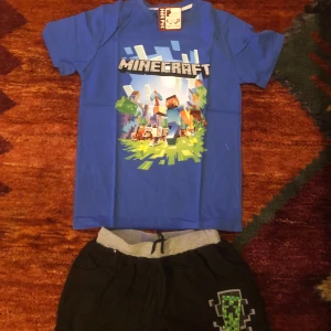 Blå Minecraft t-shirt med shorts alla storlekar finns - Säljer en blå t-shirt med Minecraft-tryck. Perfekt för alla fans av spelet! Bra present till tonåring/barn