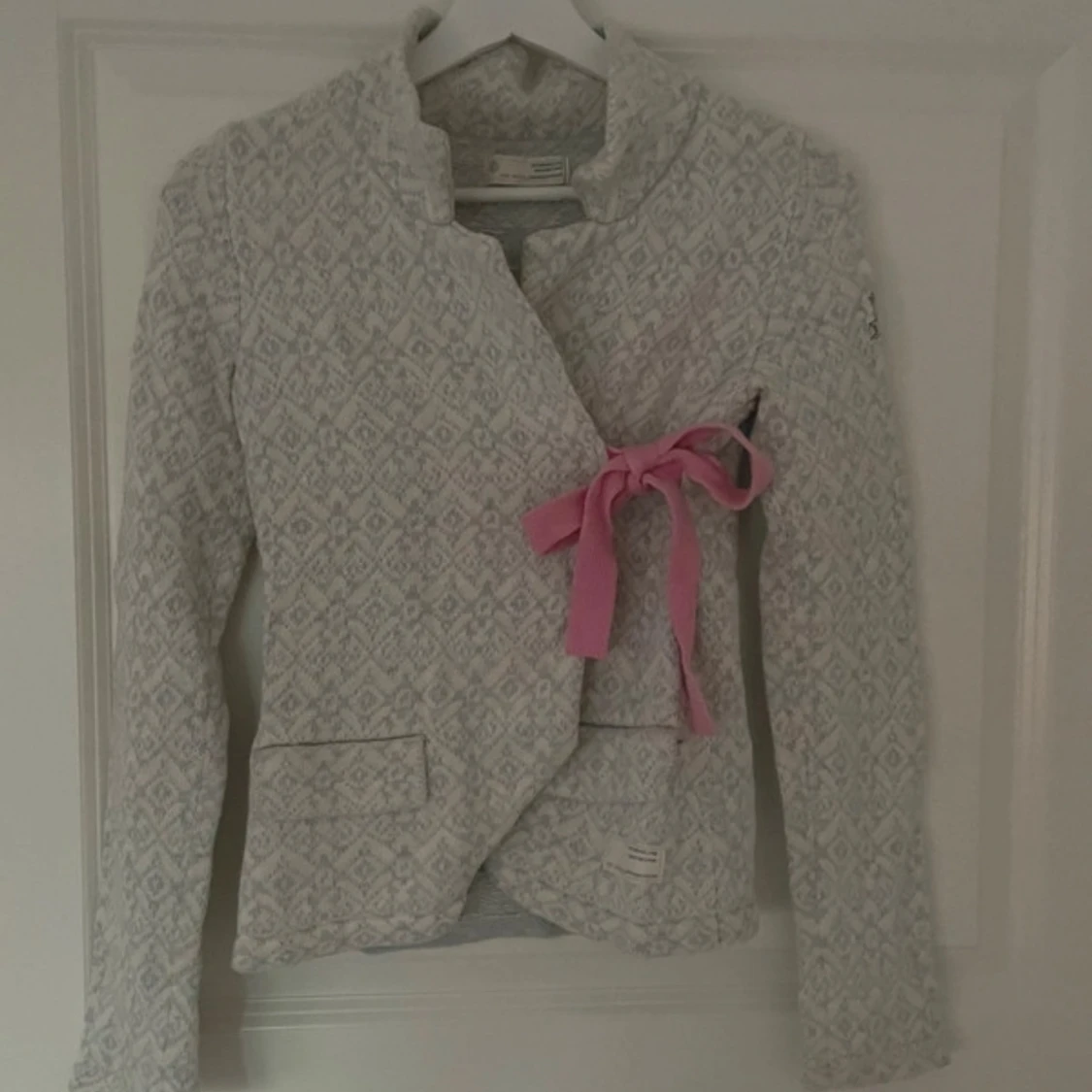 Grå mönstrad kofta med rosa detaljer