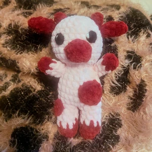 Handgjord virkad amigurumi ko - Söt handgjord amigurumi i mjukt garn. Den har en rosa kropp med röda detaljer på nos, öron och fötter. Perfekt som en unik present eller dekoration.  