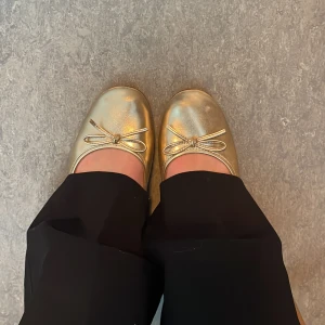 Guldiga ballerinaskor med rosett - Guldiga ballerinaskor. Har lite defekter (se bild 4) 🥰
