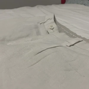 Beige linnebyxor med knappar - Snygga beige linnebyxor med knappar och fickor baktill. Perfekta för en stilren look. De har en klassisk passform och är tillverkade i ett lätt och luftigt material.