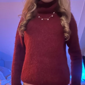 Vinröd polotröja - Säljer en mysig vinröd polotröja med långa ärmar. Perfekt för kyliga dagar och ger en stilren look. Tröjan är enkel att matcha med olika outfits.