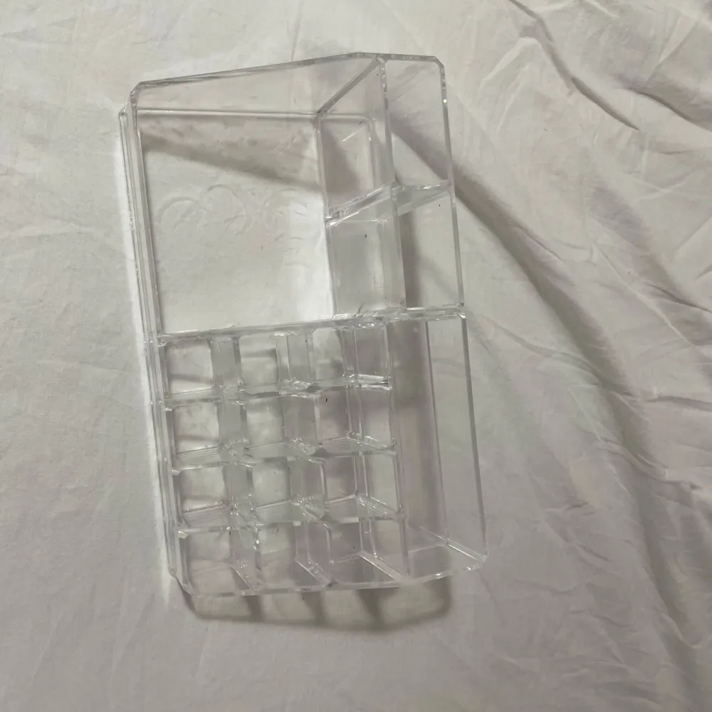 Praktisk transparent sminkorganiserare med flera fack för att hålla ordning på ditt smink. Perfekt för läppstift, borstar och andra små sminkprodukter. Tillverkad i klar akryl för enkel överblick.. Asusteet.