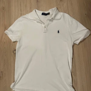 Vit kortärmad pikétröja från Ralph Lauren - Säljer en stilren, vit Ralph Lauren piké. Köpt i somras, inga fläckar och storlek S (Amerikanskt mått), passar som medium.