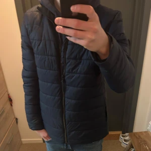 Mörkblå quiltad jacka Matinique - En riktig snygg mörkblå quiltad jacka från Matinique. Jackan har en dragkedja framtill och långa ärmar. Perfekt för kyligare dagar med sin stilrena design och bekväma passform. Storlek M Modellen är 176!Priset är inte hugget i sten! Om du har några funderingar eller prisförslag är det bara att fråga! 