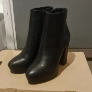 Svarta boots med klack - ANNA FIELD - Snygga svarta boots med hög klack och dragkedja på sidan. Perfekta för att ge en stilren look till din outfit. Tillverkade i skinn för en elegant finish. Stlk 38