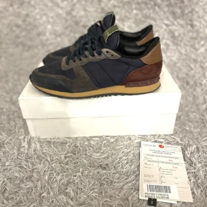 Valentino Rockrunner - Fina Rockrunners! | Skorna är i fint skick men har några tecken på användning, flärparna i fram har lossnat lite men det går att limma tbx om man skulle vilja de ingen annan del av sulan sitter löst👌| Till skorna medkommer box, 2 dustbags, valentino kort och äktahetscertifakt! | Storlek 42. | Ställ gärna frågor innan du köper! 