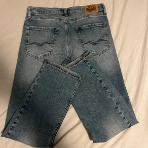 Replay jeans 14y slim/straight  - Snygga blå jeans med en klassisk rak passform. De har en ljus tvätt och är utrustade med fem fickor och en dragkedja. Perfekta för en avslappnad stil.