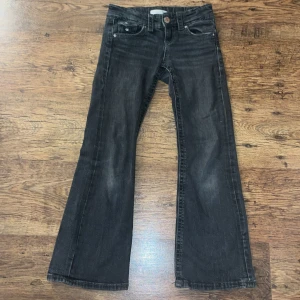 Svarta bootcut jeans från Gina Tricot - Snygga svarta bootcut jeans från Gina Tricot. De har en klassisk femficksdesign och en knappgylf. Perfekta för en stilren look.