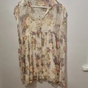 Blommig klänning från Denim & Supply Ralph Lauren - Charmig blommig klänning från Denim & Supply Ralph Lauren i en luftig design. Klänningen har en krage och är ärmlös, perfekt för varma dagar. Den har ett romantiskt blommönster i mjuka pastellfärger.