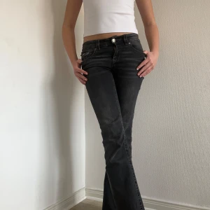 Svarta bootcut jeans - Snygga svarta bootcut jeans med låg midja och klassisk femficksdesign. Jeansen har en stilren look med knapp och dragkedja framtill. Jag är 169 för referens. Midjemått 38 cm. Innerbenslängd 76 cm. 💗