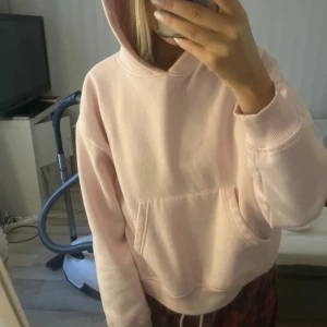 Ljusrosa hoodie lager157 - Säljer en ljusrosa hoodie med en stor ficka framtill och en mysig huva. Perfekt för en avslappnad stil. Passar bra till jeans eller leggings. Från lager 157 i storlek xs. 