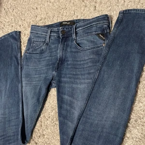 Blå jeans från Replay - Snygga blå jeans från Replay i modellen Anbass. Jeansen har en modern passform och är perfekta för en stilren look. Och är i riktigt bra skick.