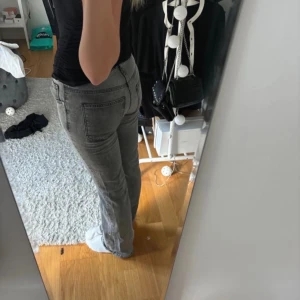 Grå jeans  - Snygga grå jeans med en klassisk straight passform. De har en normal midja och är perfekta för en avslappnad stil. Jeansen har traditionella fem fickor och en dragkedja framtill.