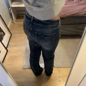 Mörkblå jeans med låg midja - Snygga mörkblå jeans med låg midja och en klassisk femficksdesign. Jeansen har en diskret tvättad look och är perfekta för en avslappnad stil. De har en knapp och dragkedja framtill.