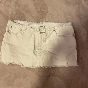 Vit jeanskjol från Pull&Bear - Säljer en snygg vit jeanskjol från Pull&Bear i storlek S. Kjolen har en fransig kant upp och nere .oandvänd , mini kjol 