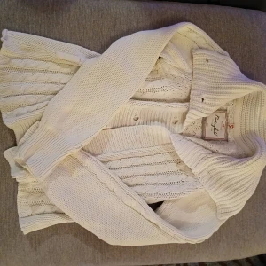 Vit stickad kofta  - Säljer en stilren vit stickad kofta från cottonfield Koftan har ett snyggt stickat mönster och knappar framtill, tyvärr saknas en knapp men går lätt att fixa❤️. Perfekt för kyliga dagar med sin långa ärmar och bekväma passform. Ett måste i garderoben! 🤍