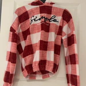 Röd och vit rutig hoodie och byxor från Trendyol pyjamas - Säljer ett mysigt set med röd och vit rutig hoodie och matchande byxor från Trendyol. Hoodien har texten 'every simple moments count' på framsidan och byxorna har en bekväm resårmidja med snörning. Perfekt för en avslappnad dag hemma! Kan användas som pyjamas också! Skulle säga att storleken är mindre än det som står (skulle säga S eller till och med XS).