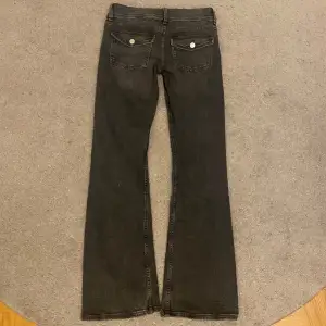 Säljer dessa svarta bootcut jeans från Gina Tricot. De har två silver knappar fram och även knappar på fickorna där bak💕
