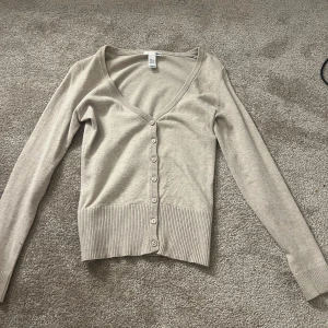 Beige kofta från H&M - Säljer denna jättefina koftan från hm. Säljer pågrund av den inte kommer till användning.
