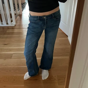 Low waist bootcut  - Säljer ett par klassiska blå jeans med bootcut. De har en låg midja och är perfekta för en avslappnad stil. Jeansen har en dragkedja och knappar framtill. Köpte i usa på hollister och säljer för att de är för korta! Skit snygga💙🩵w28 l30
