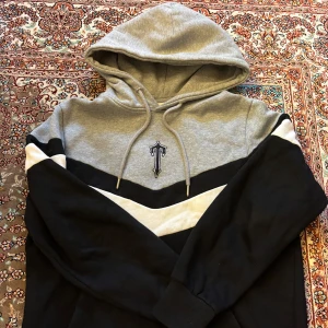  Trapstar Set  - Säljer en snygg grå och svart set från  Trapstar med en vit detalj i ett V-format mönster. Hoodien har en justerbar huva med snören och ett tryck framtill. Perfekt för en avslappnad stil. Inga mer bilder vid frågor varsågod och fråga 