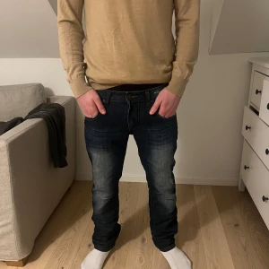 Mörkblå vintage jeans - Snygga mörkblå jeans med en klassisk straight passform. Byxorna har en midwaist design och är tillverkade i denim. Perfekta för en avslappnad stil.