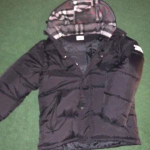 Burberry jacka - Snygg jacka från burberry som passar perfekt inför vintern med snyggt material på insidan av luvan. på jackan kan man ta av armarna och göra de till en väst vilket gör de perfekt inför sommaren OBS! priset kan diskuteras 