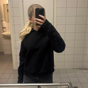 Svart hoodie - Säljer en klassisk svart hoodie med långa ärmar och en bekväm passform. Använd fåtal gånger