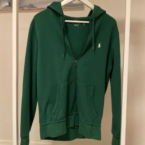 Grön hoodie från Ralph Lauren - Säljer en snygg grön hoodie från Ralph Lauren med dragkedja. Perfekt för en avslappnad stil. Nypris 1700 köpte på deras hemsida. Säljer då jag inte använder längre.