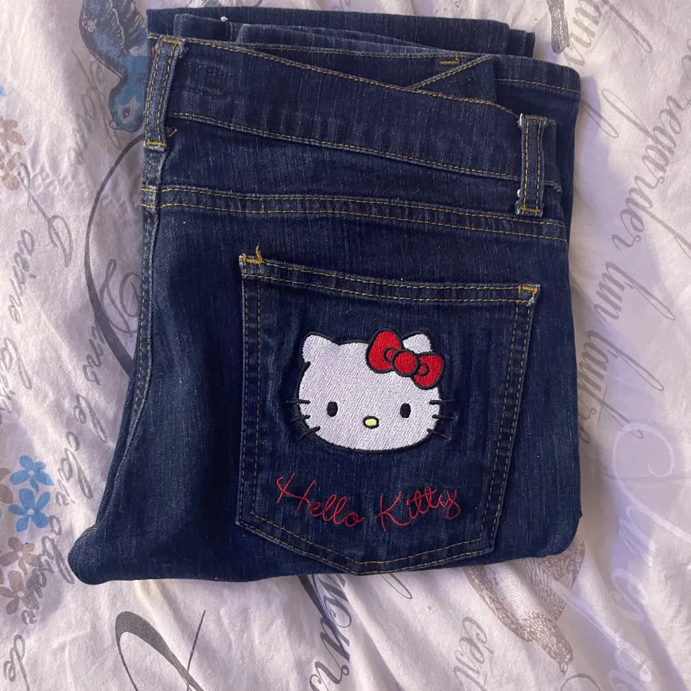 Mörkblå jeans med ett sött Hello Kitty-broderi på bakfickan. Jag skulle säga att det är straight jeans och dom är väldigt lågmidjade.Skulle säga att den passar storlek 32 eller 34 då den är lite liten för mig som brukar ha storlek 36. Jag tror den inte säljs längre och det är även äkta Sanrio. Det finns inga defekter.priset går att diskuteras!. Farkut & Housut.