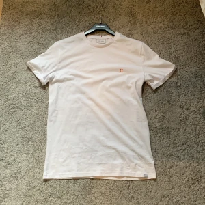 Vit t-shirt från Les Deux - Säljer en stilren vit t-shirt från Les Deux. Fick den i julklapp och har ej kommit till användning. Pris börjar på 229kr. Helt oanvänd!