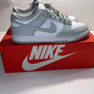 Nike Dunks grå - Snygga Nike Dunk sneakers i grå, Använda några gånger men fortfarande väldigt bra skick och inga defekter som man ser på bilderna. Lite stora i storleken så passar både 41 och 42.