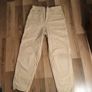 Beige high waist byxor från Lee - Säljer ett par beige high waist byxor från Lee, "Stella Tapered", W27, L31. Skitsnygga! Har använts få gånger. 