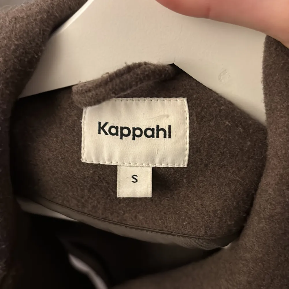 Säljer en snygg brun kappa från Kappahl i storlek S. Jackan har stora fickor framtill och knäpps med knappar. . Takit.