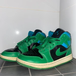 Nike Air Jordans i grönt och blått - Snygga Nike Air Jordans i en cool färgkombination av grönt, blått och svart. Skorna har en klassisk design med snörning och en bekväm passform. Perfekta för dig som vill sticka ut med stil.