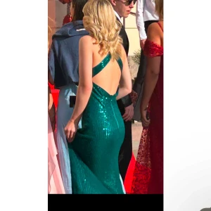 Grön Balklänning med paljetter  - Nu säljer jag min jätte fina balklänning då den inte kommer till användning.  (Använd endast 1 gång).  Den har en V-ringning, öppen rygg och slits längst benet.💚💚💚skriv till mig om du har frågor eller vill ha flera bilder, samt diskutera priset 