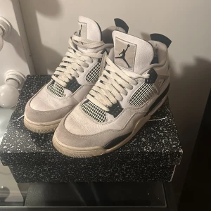 Nike Air Jordan 4 Retro - Säljer ett par Nike Air Jordan 4 Retro i vit och grå färg. Säljer skorna då det inte kommer till användning, lite trasigt vid hälen men går o fixa. Super sköna under vintern!  De är köpta på kicks N Stuff i Göteborg. Kan gå ner lite i pris vid snabb affär
