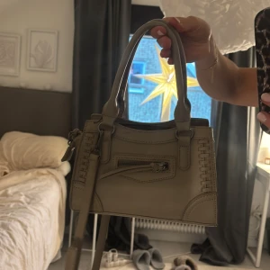 Beige handväska med dragkedja - Säljer en snygg beige handväska i syntetmaterial.  Perfekt för både vardag och fest! 👜✨
