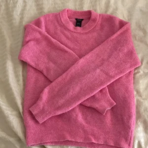 Rosa stickad tröja från Lindex - Säljer en superfin rosa stickad tröja från Lindex i storlek S. Den är perfekt för kyliga dagar med sin mjuka och mysiga känsla. Tröjan har långa ärmar och en klassisk rund halsringning. Passar perfekt till både jeans och kjol!