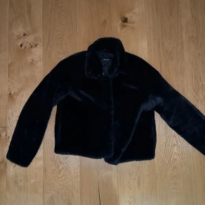 Svart pälsjacka - Säljer en supermjuk och stilren svart pälsjacka. Perfekt för att hålla sig varm och snygg under kyliga dagar. Jackan har en klassisk design med långa ärmar och en bekväm passform. Ett måste för garderoben i vinter!
