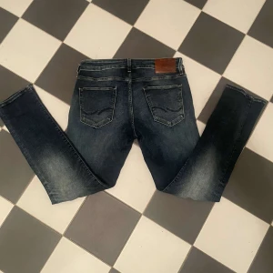 Blå jeans från Jack & Jones - Säljer ett par snygga blå jeans från Jack & Jones. De har en klassisk femficksdesign och en lätt slitning för en cool look. Perfekta för en avslappnad stil. Slim pass form. Strl 31/30. Pris kan absolut diskuteras 