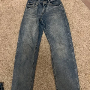 Levi's Loose Taper jeans - Säljer ett par klassiska Levi's Loose Taper jeans i en snygg blå tvätt. De har en avslappnad passform med avsmalnande ben och traditionella fem fickor. Perfekta för en casual look.