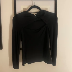 Svart långärmad topp med knutdetalj - Säljer denna snygga svarta långärmade topp med knutdetalj vid halsen. Använd fåtal gånger och är i bra skick! Pris kan diskuteras🩷