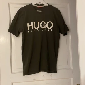 Olivgrön t-shirt från Hugo Boss - Snygg olivgrön t-shirt från Hugo Boss i storlek small. Tillverkad i mjukt och bekvämt material. Som ny
