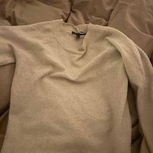 Beige stickad tröja - Mysig beige stickad tröja med rund halsringning och långa ärmar. 