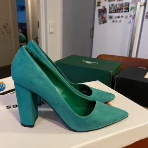 Turkosa pumps med blockklack - Snygga turkosa pumps med en stabil blockklack och spetsig tå. Perfekta för att ge en färgklick till din outfit. Tillverkade i ett mjukt material som ger en lyxig känsla.Använda bara en gång 
